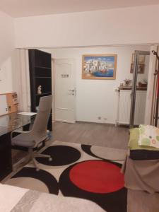 a living room with a desk and a chair and a table at Residence Lilac in Brussels