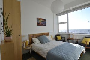 a bedroom with a bed and a large window at Westpoint Apartments in West Bay