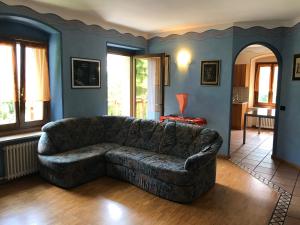 un sofá de cuero en una sala de estar con paredes azules en Appartamento sul Lago di Molveno, en Molveno