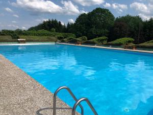 a large swimming pool with blue water at Ferienhaus im Feriendorf Freilingen (Eifel). in Freilingen