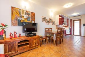 uma sala de estar com uma televisão e uma mesa de jantar em La casa del sole em Chia