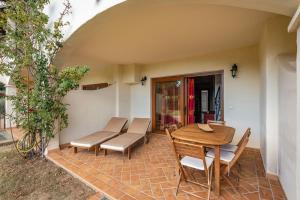 Un patio con una mesa y sillas de madera. en La casa del sole, en Chia