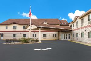 un grand bâtiment avec un drapeau devant lui dans l'établissement Econo Lodge, à Lake Mills