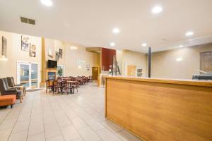 a restaurant with a bar and tables and chairs at Econo Lodge in Lake Mills