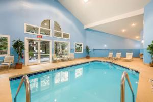 a pool in a large room with chairs and tables at Econo Lodge in Lake Mills