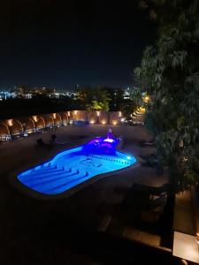a swimming pool lit up in blue at night at Al Baeirat Hotel in Luxor