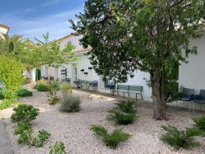 a garden with benches and a tree in front of a building at Ermita del Carmen Híjar in Híjar