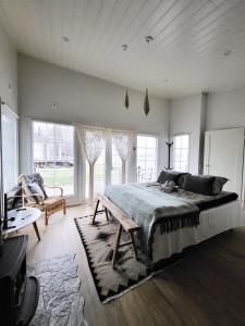 Lakehouse Oulu في أولو: غرفة نوم بسرير واريكة ونوافذ