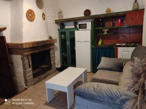 een woonkamer met een bank en een open haard bij Azahar in Lecrin
