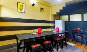 a dining room with a table and chairs and a refrigerator at Treebo Trend JKR Residency in Shillong