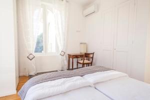 a white bedroom with a bed and a desk at CLOSE CROISETTE-MODERN-A/C-CONGRESS-BEACHES in Cannes