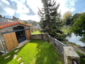 a yard with a stone house with a wooden door at La Demoiselle de Bohardy in Montrevault