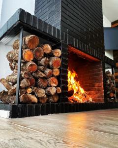 a brick fireplace with a pile of logs in it at Casa Rural VILLA KAIROS in Ajofrín