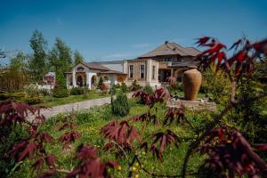 a house with a garden in front of it at Pensiunea Eden in Târgu Neamț