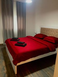 Schlafzimmer mit einem roten Bett mit roter Bettwäsche und roten Kissen in der Unterkunft Apartman Viktorija in Žabljak
