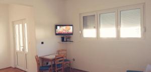 a room with a table and a television on a wall at Apartman studio Katarina in Golubac