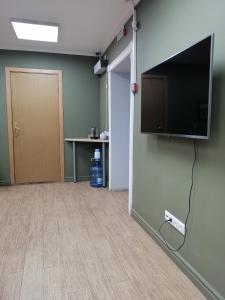an empty room with a flat screen tv on a wall at Ilyinskiy Hostel in Nizhny Novgorod