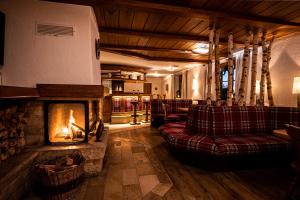 a living room with a fireplace and couches at Hotel Johanneshof in Oberstaufen