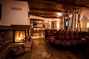 uma sala de estar com lareira e sofás em Hotel Johanneshof em Oberstaufen