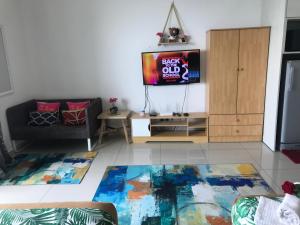 uma sala de estar com uma televisão e um sofá em Studio I-Soho D'Gunduls Homestay by DGH I-CITY em Shah Alam