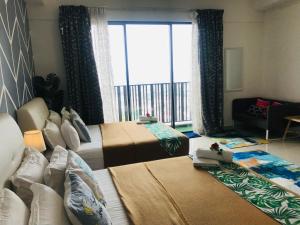 a bedroom with two beds and a large window at Studio I-Soho D'Gunduls Homestay by DGH I-CITY in Shah Alam