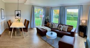 sala de estar con sofá y mesa en Blick ins Grüne- Premium-FeWo, en Göhren-Lebbin