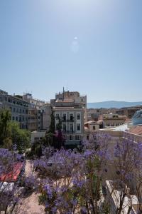 Aussicht vom Dach eines Gebäudes mit lila Blumen in der Unterkunft Emporikon Athens Hotel in Athen