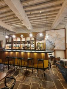 a bar with black stools in a room at Maison Philippe Le Bon Hôtel, Restaurant & Bar le 19 in Dijon