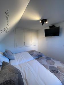 a bedroom with a large white bed and a flat screen tv at Ô Secret du Wérihay in Spa +24 photos