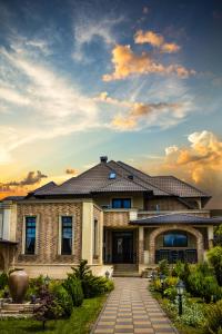 a house with a tile roof and a driveway at Pensiunea Eden in Agapia