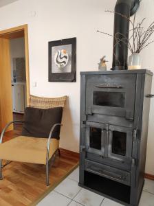 a living room with a stove and a chair at Ferienwohnung Imberger Horn - Sonthofen in Sonthofen