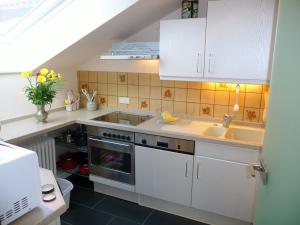 a kitchen with white cabinets and a sink at Ferienwohnung Imberger Horn - Sonthofen in Sonthofen