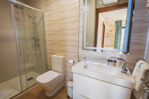 un bagno con wc, lavandino e doccia di Apartamentos Mirador de Vidío a Cudillero Altre 28 foto