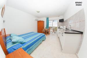 a bedroom with a bed and a kitchen with a sink at Apartamentos Rurales Santos in Benajarafe