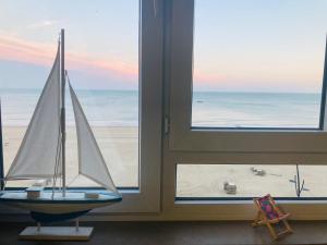 a toy sailboat on display in front of a window at Appartement Zeedijk Blankenberge - near Brugge in Blankenberge