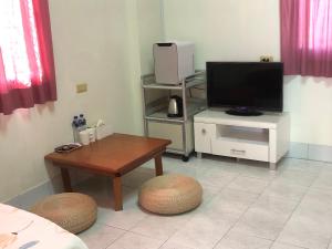 Una sala de estar con un televisor y una mesa. en 聖甲虫空間, en T'u-ch'eng-tzu