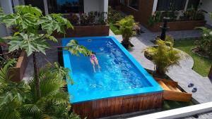 eine Person, die in einen Pool im Hinterhof springt in der Unterkunft Toucan Platinum Suites Aparthotel in Mindo