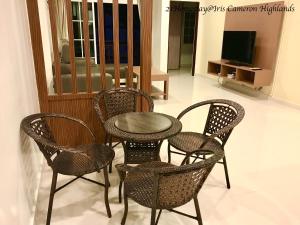 a table and four chairs and a television in a room at 21Homestay (3-Bedrooms) @ Iris Cameron Highlands in Cameron Highlands