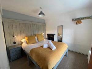 a bedroom with a large bed with yellow pillows at The Old Farmhouse in Bryn-crug