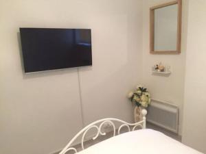 TV de pantalla plana en la pared de un dormitorio en MAGNIFIQUE T3 85m2 VIEUX PORT/CORNICHE, en Marsella