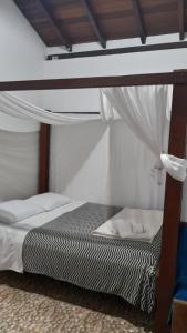 a bedroom with a bunk bed with a canopy at Guest House da Lui in Ubatuba