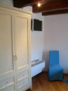 a room with a cabinet and a blue chair at La Gatta sul Tetto in Rossano
