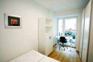 um quarto com uma cama, uma secretária e uma janela em Top Central Apartment on Karlsplatz Vienna em Viena