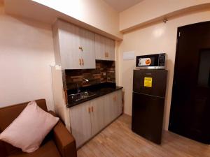 a small kitchen with a sink and a refrigerator at Affordable Baguio Condo- Goshenland towers in Baguio