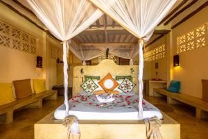 a bed with a canopy on top of it at Sunshine Hotel Zanzibar in Matemwe