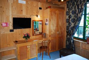 a room with a desk with a mirror and a television at Hotel LONDON in Tirana