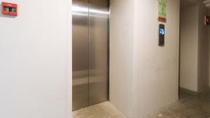 a elevator stall in a building with a sign on the wall at Eimy's Place at Urban Deca Tower by RedDoorz in Manila