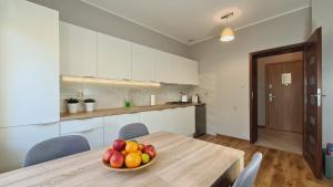 a bowl of fruit on a wooden table in a kitchen at Apartament Parkowy Piątka in Gniezno