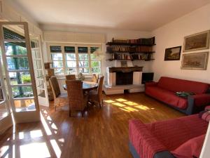 a living room with a red couch and a table at Casa vacanze Gabbianella villa con giardino lungolago Maderno in Toscolano Maderno