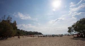 a group of people standing on a beach at Remvi Hotel - Apartments in Stoupa